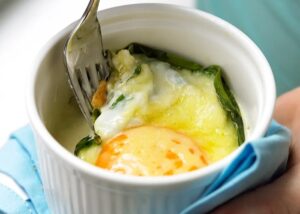 Baked eggs and cod with spinach